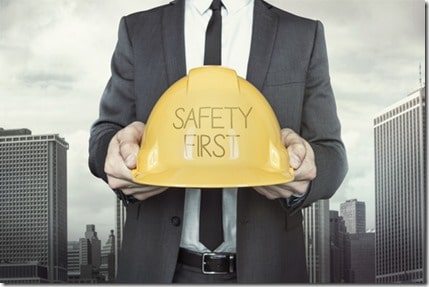 Safety first text on helmet what businessman is holding