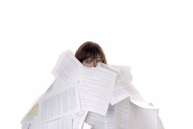 businesswoman drowning in a mountain of papers